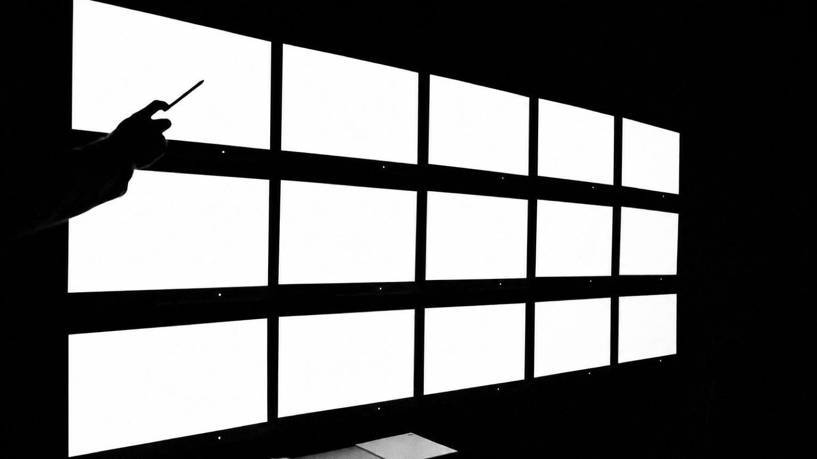 A hand reaching towards a wall of lit panels
