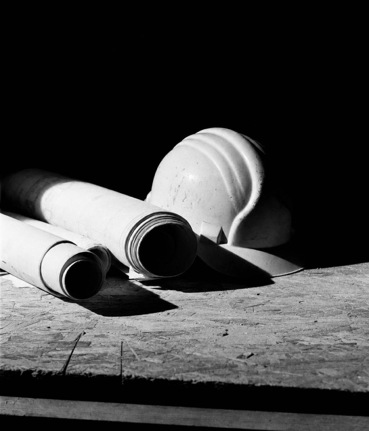 Rolled drawings and a hard hat left on a table