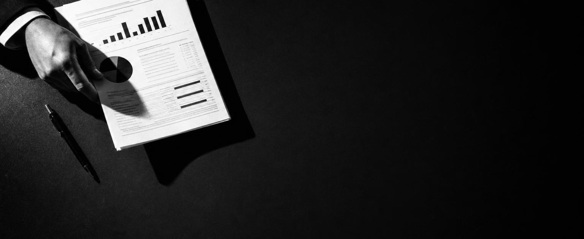 A printed report and a bar chart on a dark desk