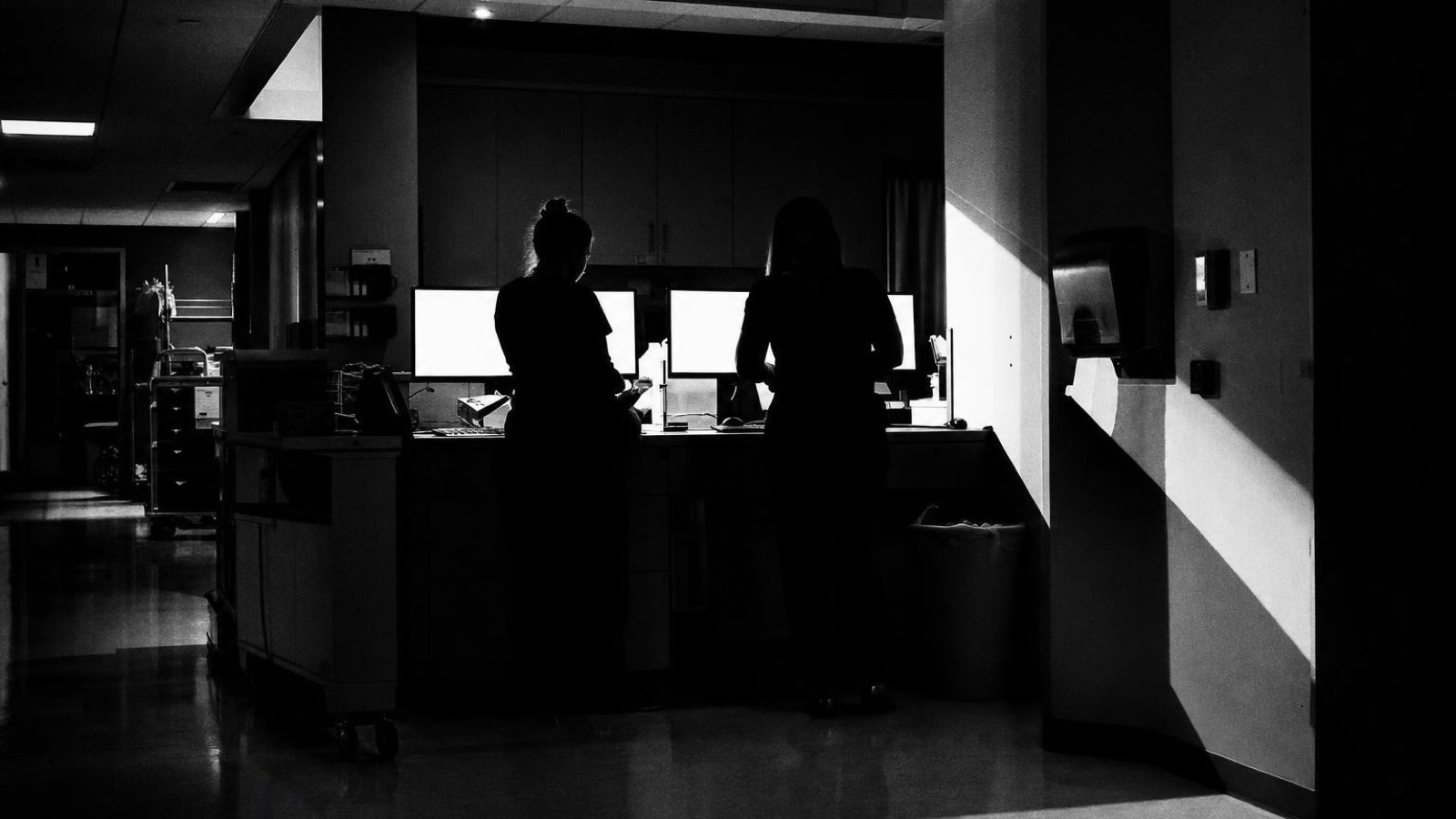Two staff at a lit reception counter